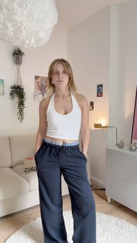 Fehér pánt nélküli felső, melyet laza, sötétkék nadrággal viselnek, amely elasztikus derékkal és állítható zsinórral rendelkezik. Sima anyag, laza szabás.