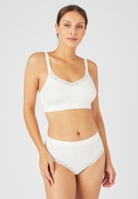 Bralette bianco con pizzo, design senza cuciture e spalline regolabili, abbinato a culotte bianche a vita alta con dettagli in pizzo.