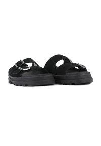 Sorte semskede sandaler med en tykk gummisåle. Designet har to justerbare stropper med metalliske aksenter og utskårne detaljer.