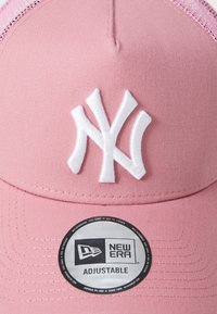 Roza bejzbolska kapa s bijelim veznim NY logom. Ima prilagodljivi snapback dizajn i tkaninu s glatkom, strukturiranom krunom.