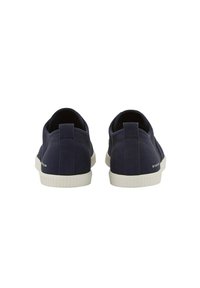 Scarpe slip-on in tela blu navy con una finitura testurizzata, suola in gomma bianca e un piccolo logo sul tallone. Bordo liscio e senza lacci visibili.