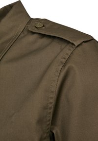 Camisa de color verde oliva con cuello puntiagudo, cierre de botones y tejido texturizado con costuras pronunciadas a lo largo de los hombros y las costuras laterales.