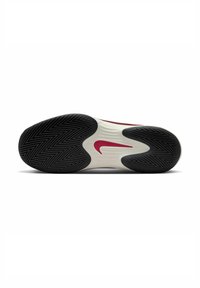 Suola di sneaker con una combinazione di colori bianco e nero, caratterizzata da un motivo a spina di pesce e un logo swoosh rosso di Nike per una migliore trazione.