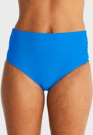 Vrouw draagt felblauwe high-waisted bikini broekjes, bij de taille en boven de dijen bijgesneden, tegen een effen lichte achtergrond.