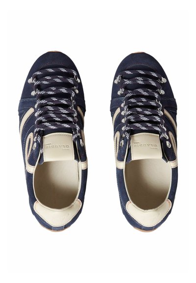 Paire de baskets en daim bleu marine avec des accents en cuir blanc et des lacets rayés noir et blanc, vues de dessus.