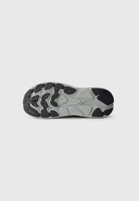 Talpa de adidași neagră și gri cu un design din cauciuc texturat, având striații multidirecționale și brandul HOKA pe secțiunea călcâi.