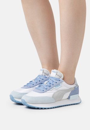 Zapatillas deportivas blancas y azul claro con materiales de malla y ante, con lengüeta acolchada, cordones azules y diseño de suela en contraste.