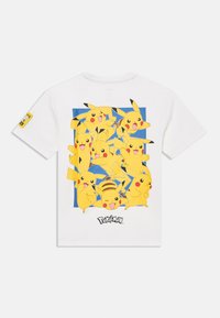 Biała koszulka z wieloma żółtymi ilustracjami Pikachu na niebieskim tle, z czarnym logo "Pokémon" na dole.