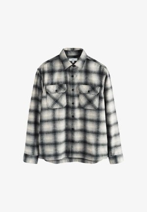 Black and white plaid flannel shirt with two chest pockets, button closure, spread collar, and a soft, textured fabric.