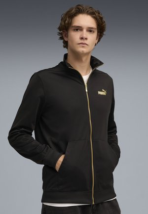 Schwarze, Reißverschlussjacke aus glattem Stoff, mit Stehkragen, Seitentaschen und einem goldenen Puma-Logo auf der Brust.