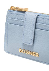 Light blue leather wallet with a textured finish, gold zip hardware, and a gold logo. Features multiple card slots and a secure closure.