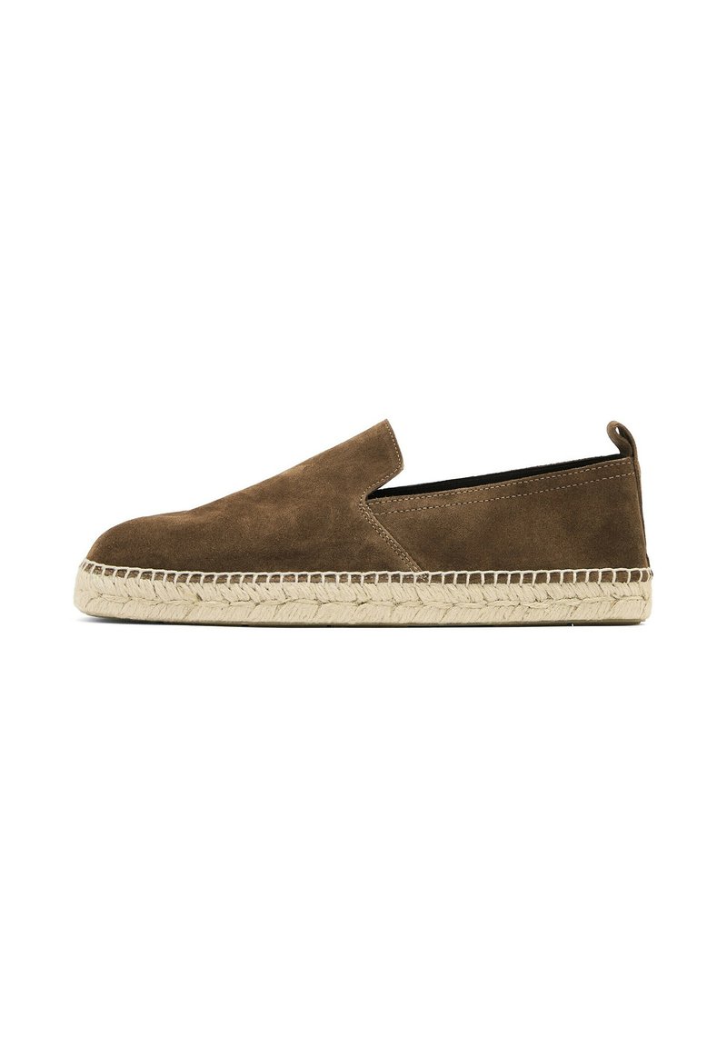 Brune ruskinds slip-on sko med en rund tå, der har en sål af jute reb og kontrasterende syninger langs kanten. Ingen synlig hardware.