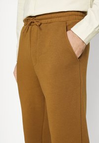 Jack & Jones JJIKANE JJBRINK PANTS - Calças de fato de treino - desert palm