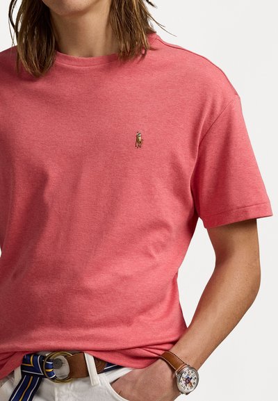 Tricou din bumbac coral cu mâneci scurte și decolteu rotund. Prezintă un mic logo brodat pe piept și o croială lejeră.