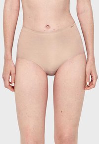 Culotte taille haute beige en tissu lisse et extensible. Dotée d'un design sans couture avec une large ceinture.