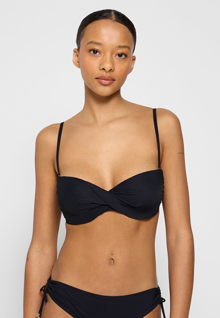 Schwarzer Bikini-Top mit gedrehtem Frontdesign, dünnen verstellbaren Schulterträgern, glatter Stofftextur, kombiniert mit passenden Unterteilen.