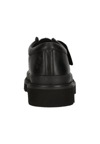 Zapato de cuero negro con punta redonda, tacón bajo y suela texturizada. Presenta un diseño de cordones planos y costuras en contraste.