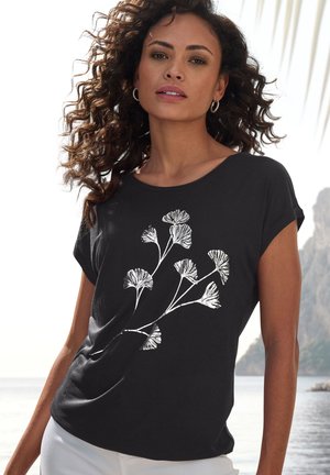 T-shirt noir à manches courtes avec un design floral blanc. Tissu doux avec une coupe décontractée et un col rond, idéal pour un usage décontracté.