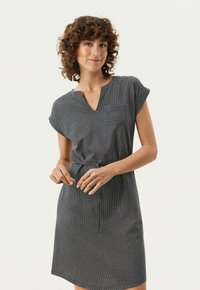 Kortsleeve klänning i marinblått med vita prickar, med V-ringning och en lös silhuett, tillverkad av lättviktsmaterial.