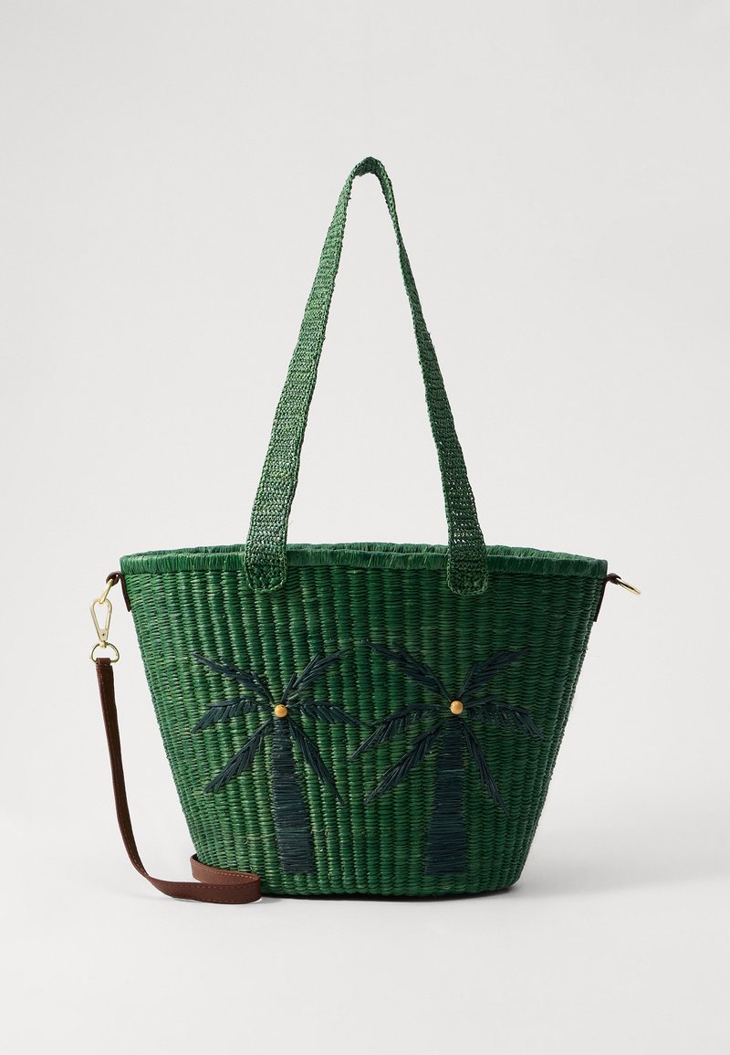 Borsa a rete verde con design di palme in verde scuro; presenta due manici e una tracolla staccabile in pelle marrone.