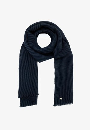 Ciemnoniebieski prążkowany szalik złożony w pętlę, z frędzlami na brzegach oraz małym kwadratowym metalowym logo blisko jednego końca, na białym tle.