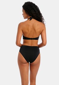 Bikini negro con diseño de cuello halter y cierre en la parte posterior. Parte inferior de talle alto con textura suave, estilo minimalista y sin estampados.