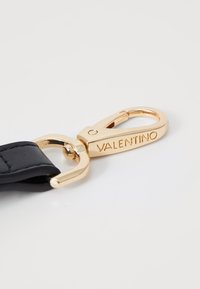 Čierny kožený remienok s pozlátenou karabínou s vyryt�ým nápisom "VALENTINO", prezentujúci elegantný dizajn a lesklý povrch.