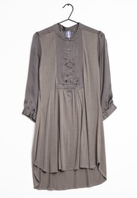 Robe longue grise à boutons avec des manches en satin et un panneau frontal, taille froncée et ourlet asymétrique, accrochée à un cintre noir.