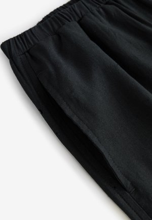 Mustad puuvillased lühikesed püksid elastse vöökohaga ja küljetaskutega, millel on lõdvestunud lõige ja sile tekstuur. Nähtavad mustrid või aksendid puuduvad.