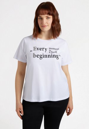 Weißes T-Shirt mit kurzen Ärmeln und schwarzem Text mit Kristallakzenten, auf dem steht: "Jeder Moment ist ein neuer Anfang", runder Halsausschnitt, lässige Passform.
