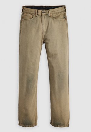 Beige denim jeans met rechte pijpen, voorste knoop, rits, riemlussen en vijfzakkenontwerp op een effen achtergrond.