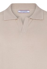 Polo beige con colletto testurizzato e chiusura a tre bottoni. Il tessuto è liscio, con un delicato motivo a maglia. Etichetta del marchio visibile.