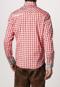 Camisa de manga larga a cuadros rojos y blancos con puños grises, que presenta detalles impresos y un cuello con botones. Tela de algodón, corte casual.