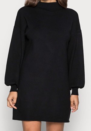 Abito maglione nero con collo alto, maniche a palloncino e polsini a coste; realizzato in morbido materiale a maglia; lunghezza fino al ginocchio.