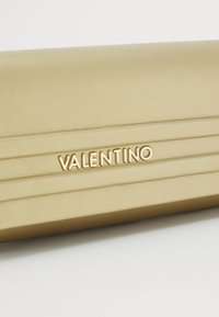Gold-tone leather clutch with a textured surface, featuring vertical pleats and the embossed "VALENTINO" logo in a prominent position.