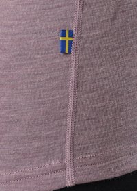 T-shirt a maniche corte color malva con tessuto testurizzato. Presenta una piccola toppa con la bandiera svedese vicino alla cucitura e cuciture a vista lungo i bordi.