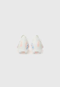 Fußballschuhe aus weißem Strickmaterial mit einem Verlauf von Koralle zu Blau, ausgestattet mit einem niedrigen Profil und einer transparenten, mit Stollen versehenen Laufsohle.