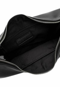 Interior de bolso de mano de cuero negro con un bolsillo con cremallera, forro de lona y un pequeño compartimento deslizante. Cierre de cremallera plateado resistente.