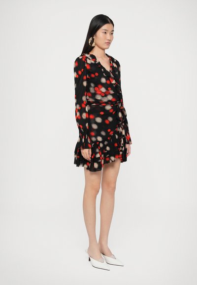 Μαύρο φόρεμα με κόκκινες και μπεζ πουά, σχεδιασμός τύπου κιμονό, μακριά μανίκια, βολάν στο τελείωμα. Φορεμένο με λευκές ψηλοτάκουνες γόβες με μυτερή μύτη.