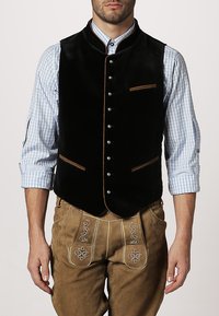 Schwarze Samtweste mit braunen Akzenten und Knöpfen, ausgestattet mit zwei Vorderaschen. Getragen über einem hellblauen karierten Hemd und beige Hosen.