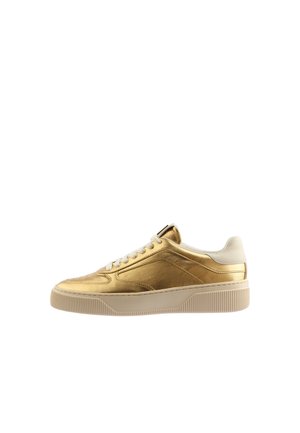 Lage sneaker in metallic goud met witte veters en een dikke witte rubberen zool, zijaanzicht op een witte achtergrond.