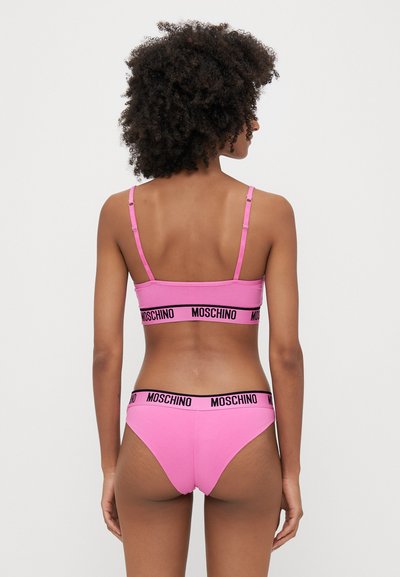 Rózsaszín pamut fehérnemű szett, állítható pántos bralette-tel és hozzá illő, csípőn szabott alsóneművel, mindkettő fekete Moschino logós pánttal.