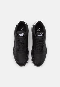 Mustat urheilutennarit synteettisellä päällisellä, valkoisilla yksityiskohdilla, nyöritys, pehmustettu kaulus sekä logo kielen ja sivun kohdalla. Kumipohja.