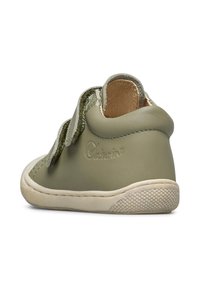 Scarpa per toddler in pelle verde con superficie texturizzata, fascia in Velcro e suola in gomma beige. Presenta un branding sottile sul lato.