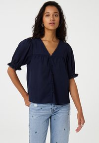 Dunkelblauses kurzärmliges Blusenshirt mit V-Ausschnitt, Knopfleiste und Rüschensäumen. Der leichte Stoff hat eine feine Textur.