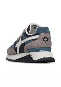 Sneakers con una toma in suede grigia e blu navy, dettagli in pelle bianca e una suola in gomma nera texturizzata. Presentano un logo sul tallone e sulla linguetta.