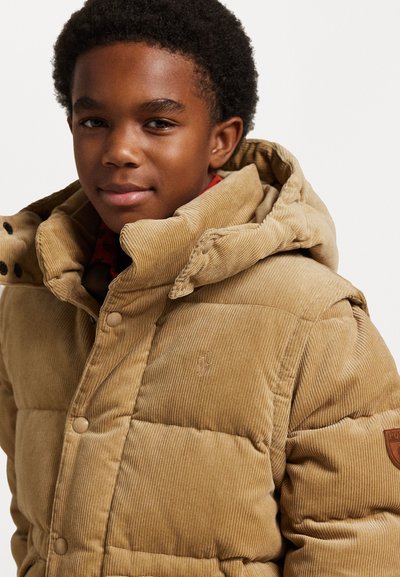 Casaco puffer de cotelê em tom de areia com colarinho alto, fechos de botão e um patch de logo na manga. Tecido texturizado com um aspeto quente.