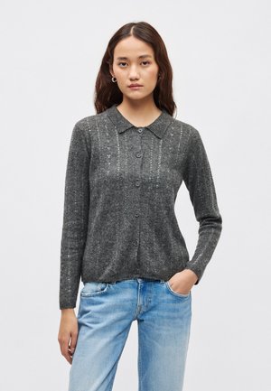 Hall hallitud kardigan kraega, millel on nööpidega kinnis ja peen tekstuuriga muster ees. Pikkade varrukatega ja pehmest materjalist.