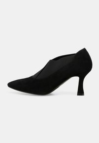 Scarpa nera in suede con tacco alto, punta affusolata e pannello laterale elastico. Caratterizzata da un tacco sottile e una texture liscia.
