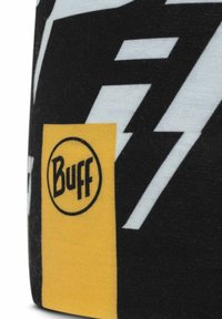 Buff headwear featuring a black and white lightning bolt pattern, with a yellow branded label displaying the "Buff" logo. Soft fabric texture.